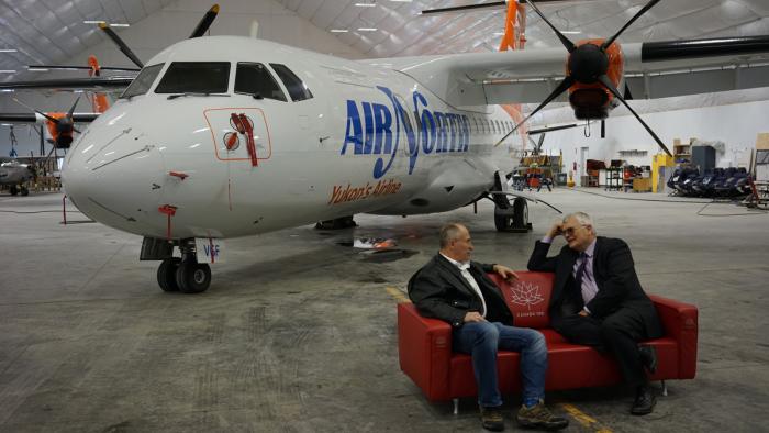 Joe et Rick parlent sur le sofa avec un nouveau ATR 42 en arrière-plan.