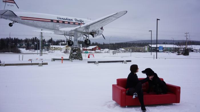 Directrice Janna Swales sur le sofa rouge avec son chien Howard Benjamin.